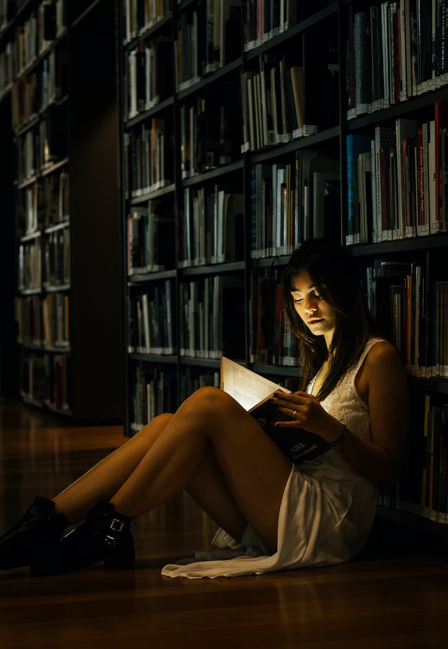woman leaning on bookshelf