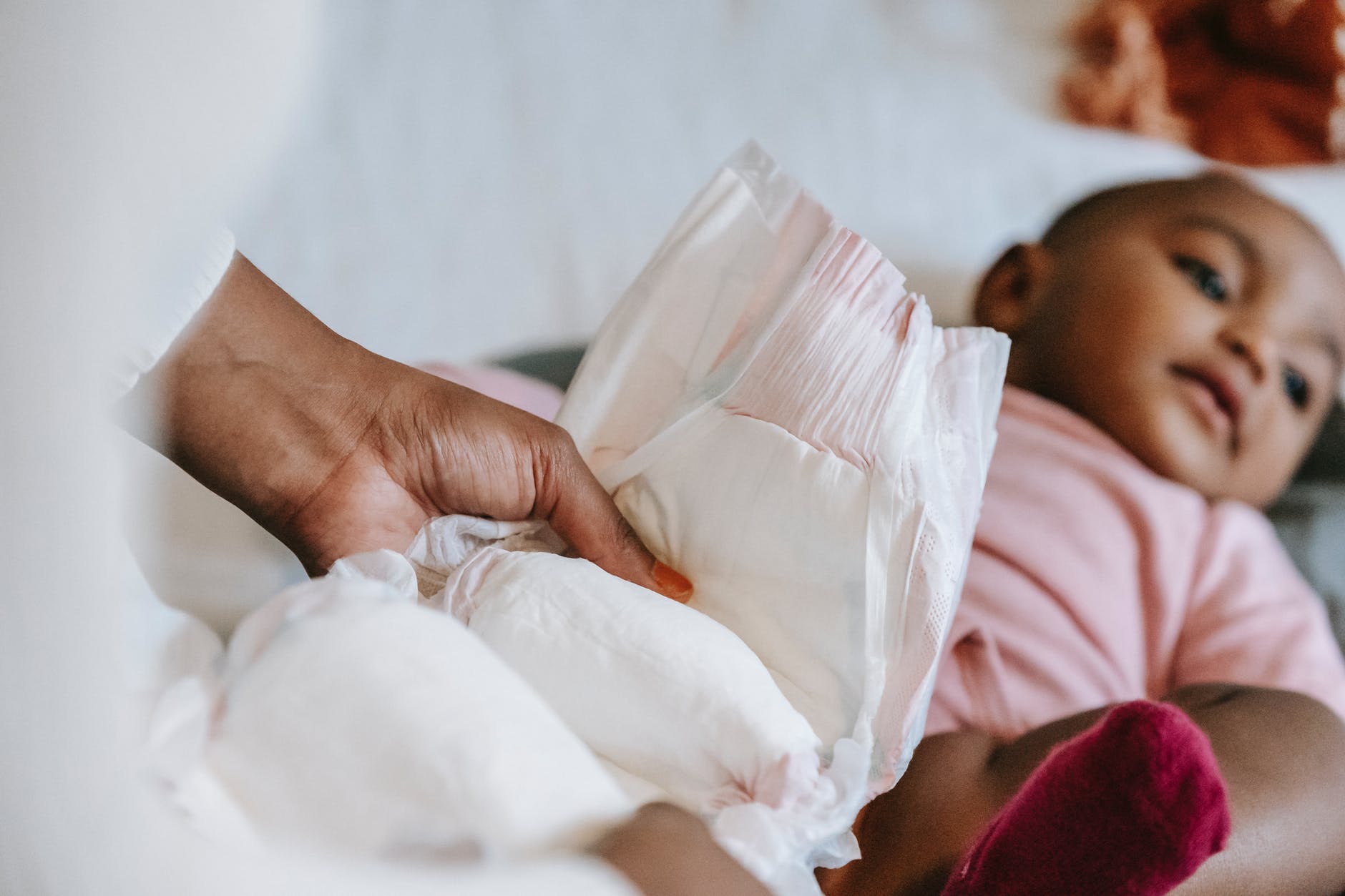 black mother changing diaper for baby