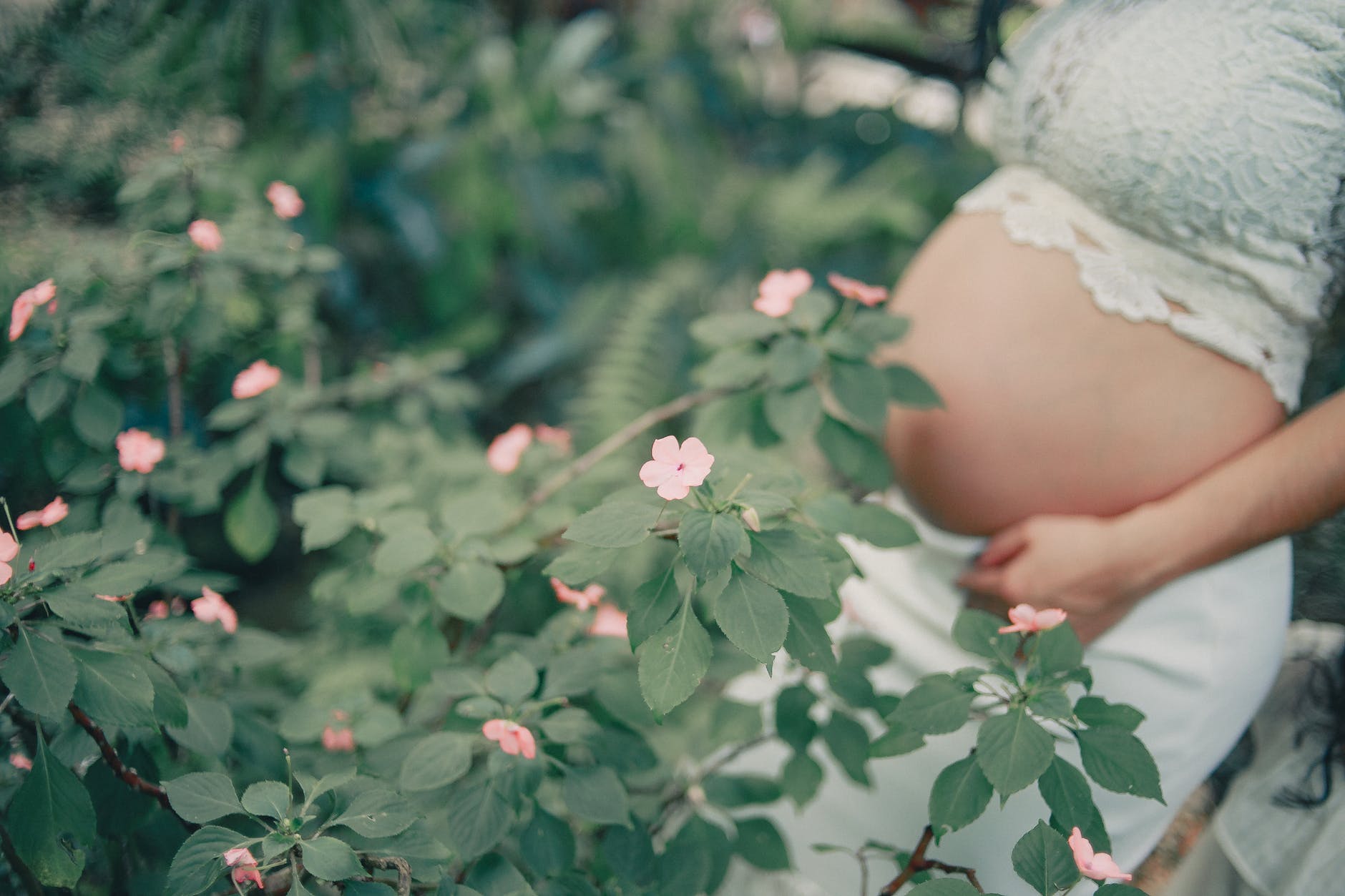 pregnant standing near the flower