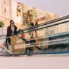 woman riding escalator