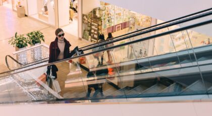 woman riding escalator