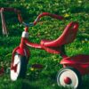 a red kid s bike on the green grass